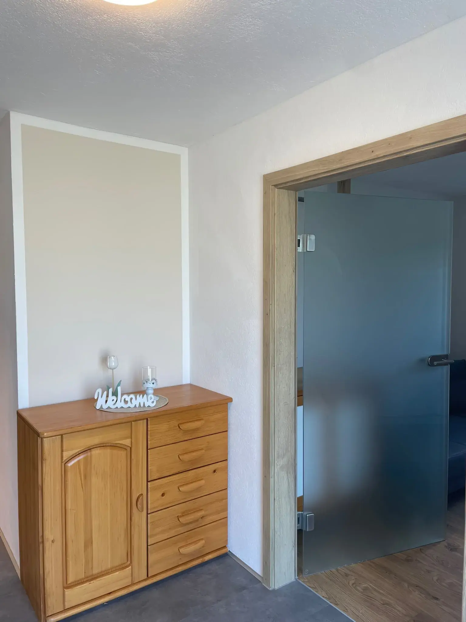 Eingangsbereich der Ferienwohnung Klärle in 88299 Leutkirch im Allgäu mit Holzkommode und Glastür