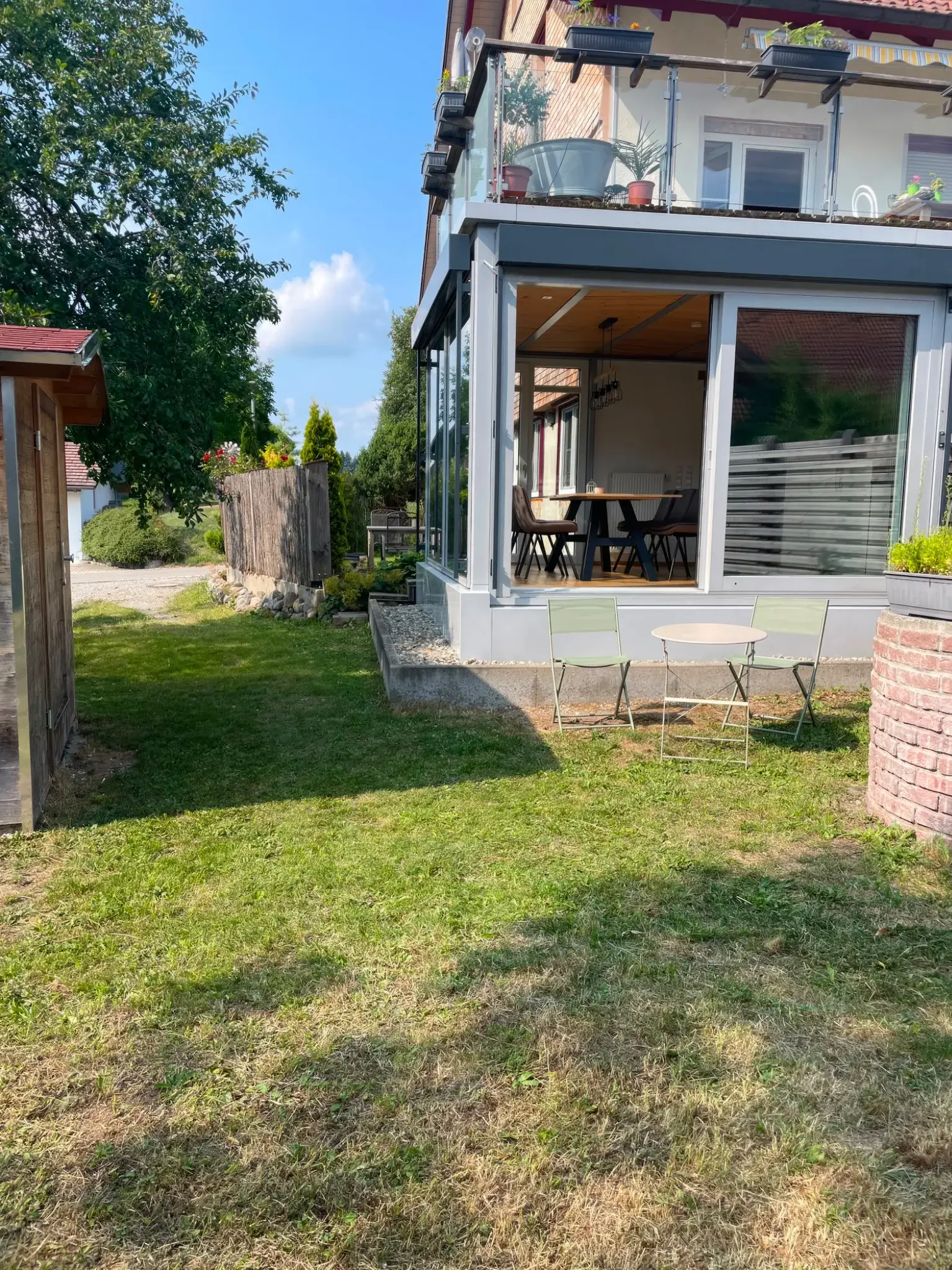Garten der Ferienwohnung Klärle in Leutkirch im Allgäu mit Gartenhaus und Blick auf den Wintergarten