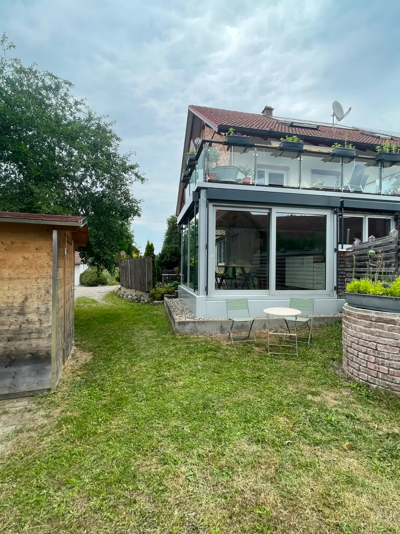 Garten der Ferienwohnung Klärle in 88299 Leutkirch im Allgäu mit Hochbeet und Wintergarten