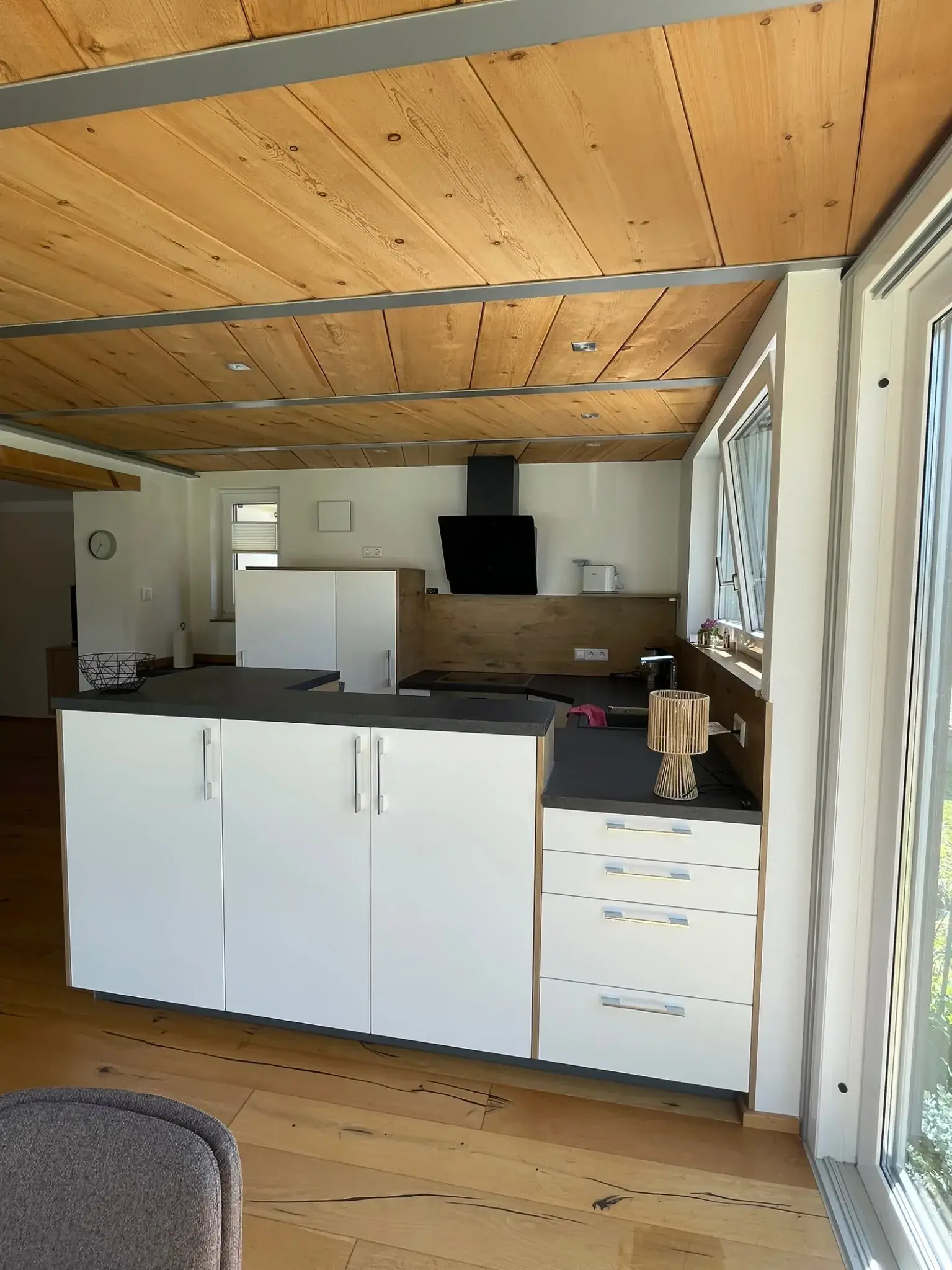 Offene Küche der Ferienwohnung Klärle in Leutkirch im Allgäu mit Holzdecke und Blick in den Wintergarten