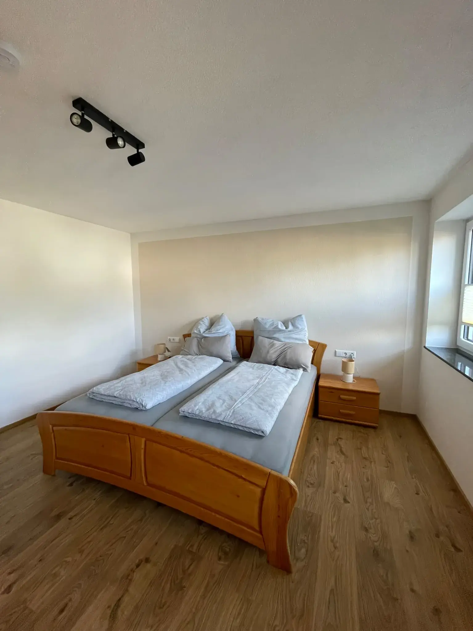 Schlafzimmer der Ferienwohnung Klärle in 88299 Leutkirch im Allgäu mit Doppelbett und Nachttischen