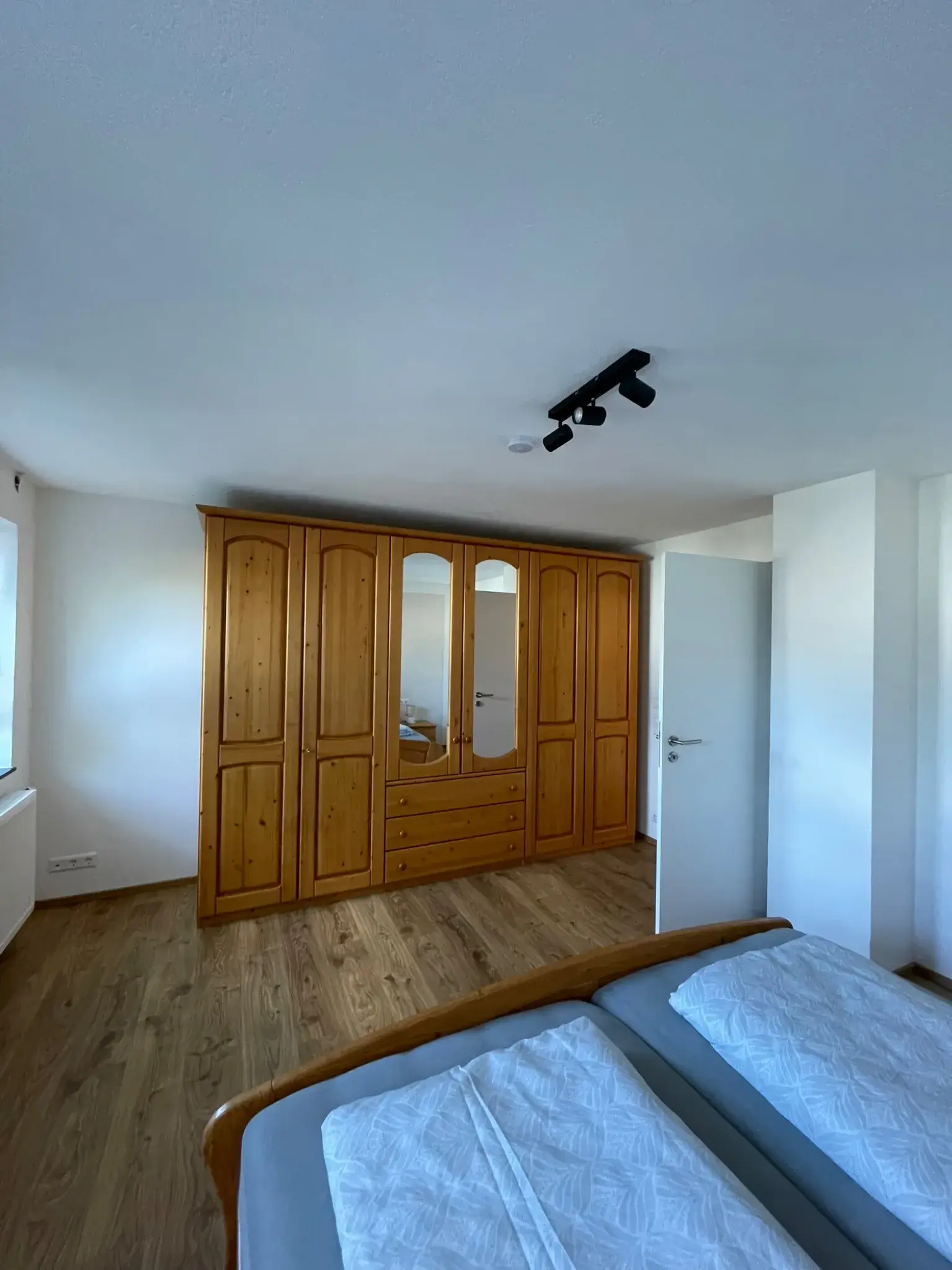 Schlafzimmer der Ferienwohnung Klärle in Leutkirch im Allgäu mit großem Kleiderschrank aus Holz